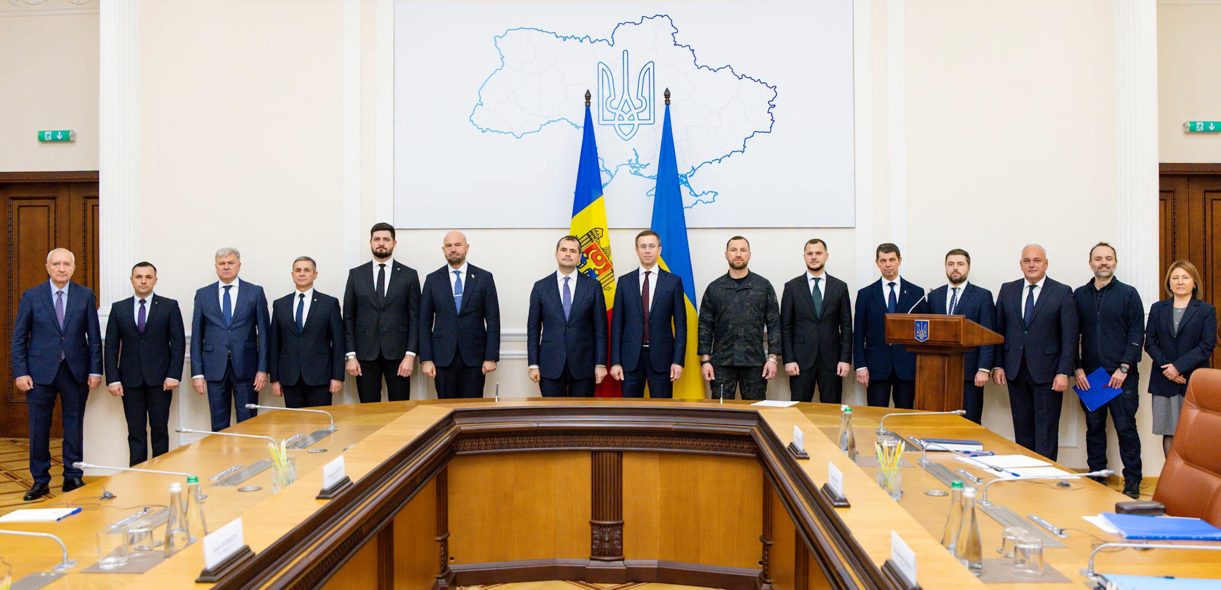 Un grup de oficiali stă într-o sală de ședințe, în fața drapelelor Republicii Moldova și Ucrainei.